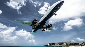white and blue aircraft above beach shoreline at daytime