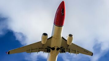 SunCountry Airlines airplane is flying in the sky with clouds