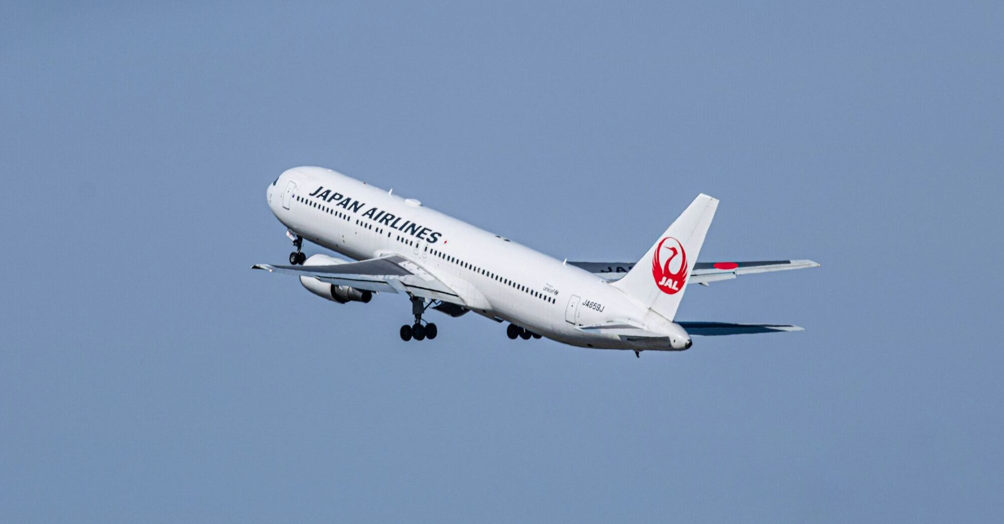 Japan Airlines airplane taking off into the sky