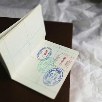 a foreign passport with stamps inside lies on the bed