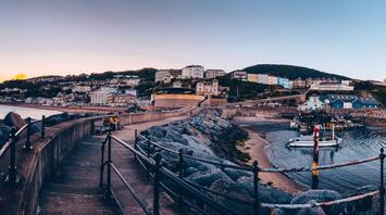 Scenic view of Ventnor Town with a coastal walkway at sunset