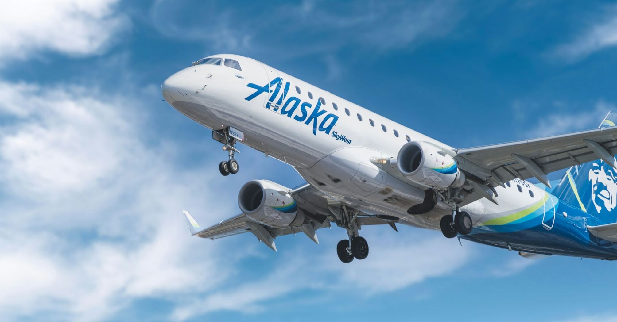 Alaska Airlines plane taking off against a blue sky