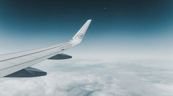 Lufthansa airplane wing in flight over clouds