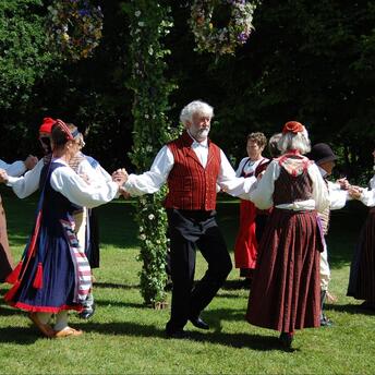 People celebrating the midsummer with traditional folk dance