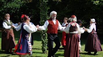 People celebrating the midsummer with traditional folk dance