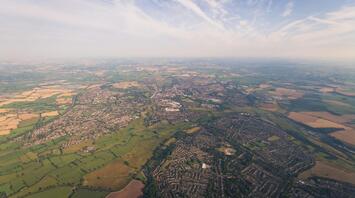 Aerial view of Staffordshire, showcasing towns, villages, and lush green fields