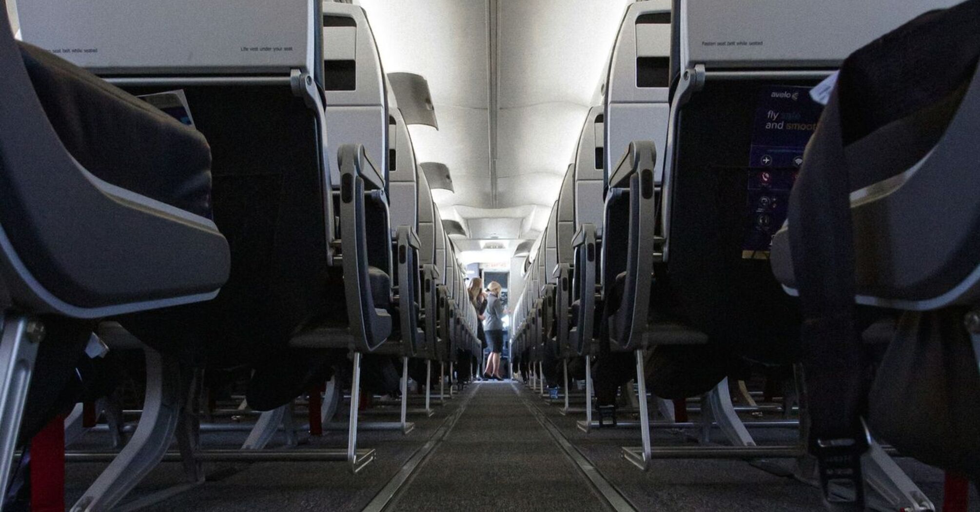 Interior view of an airplane aisle with rows of seats