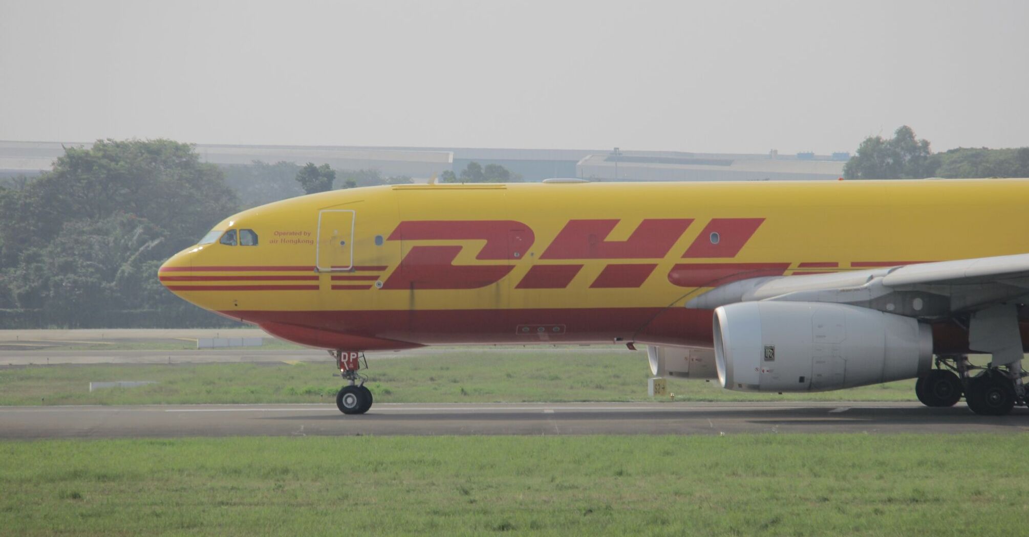 yellow and red DHL plane on airport during daytime