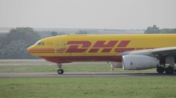 yellow and red DHL plane on airport during daytime
