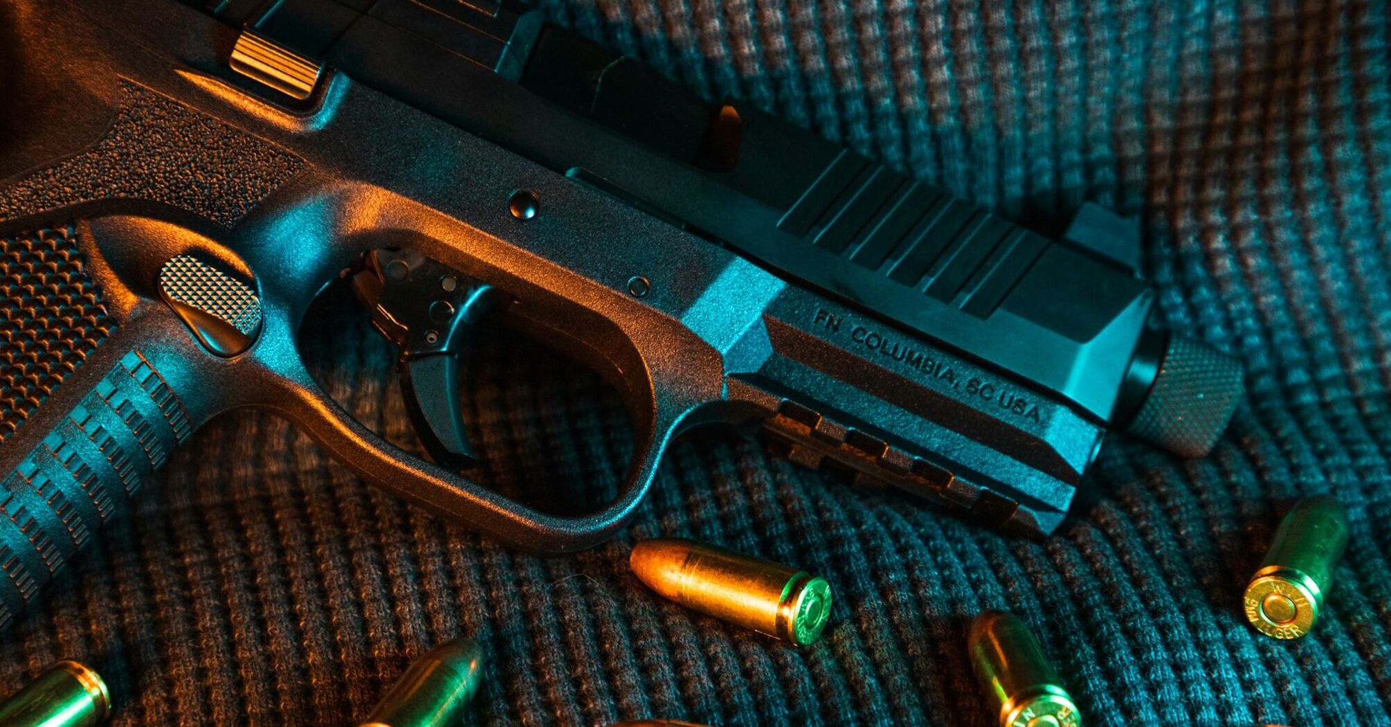 Handgun with bullets on a textured surface