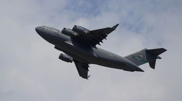 gray military jet plane under white clouds during daytime