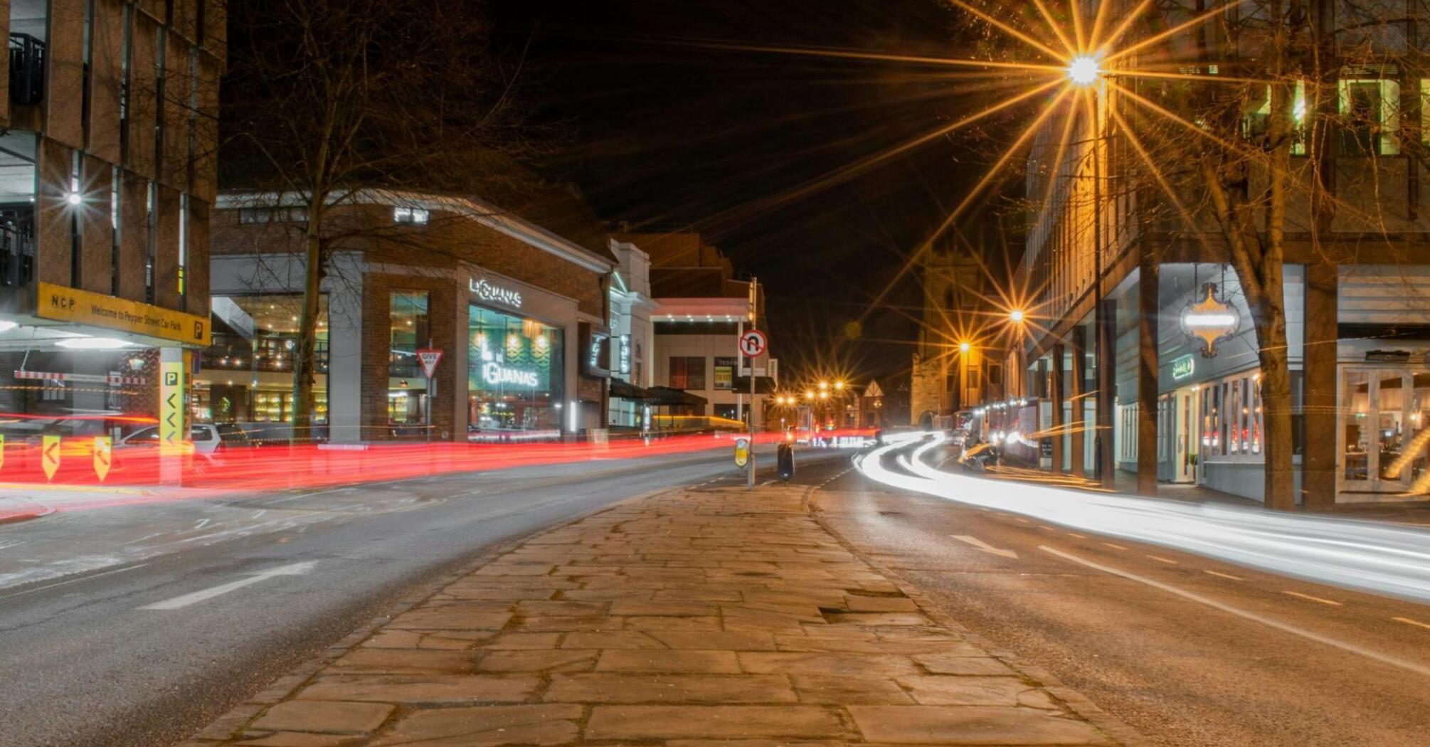 Night view of a busy street in Cheshire East with light trails from passing cars