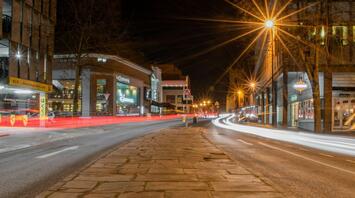 Night view of a busy street in Cheshire East with light trails from passing cars