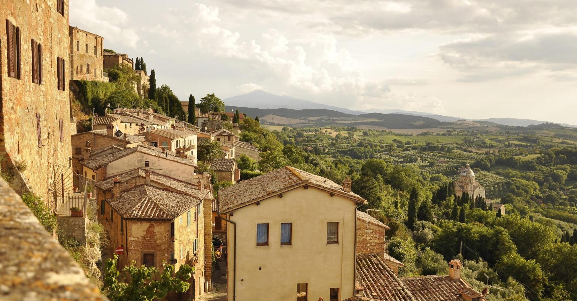 The evening sun illuminates the ancient Italian town with its terracotta roofs and picturesque landscapes