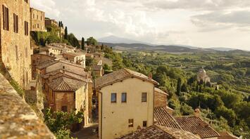 The evening sun illuminates the ancient Italian town with its terracotta roofs and picturesque landscapes