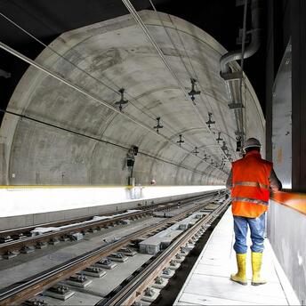 Construction worker inspecting the interior of an underground train tunnel