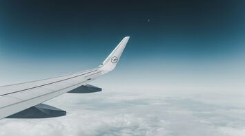 Lufthansa airplane wing flying above the clouds