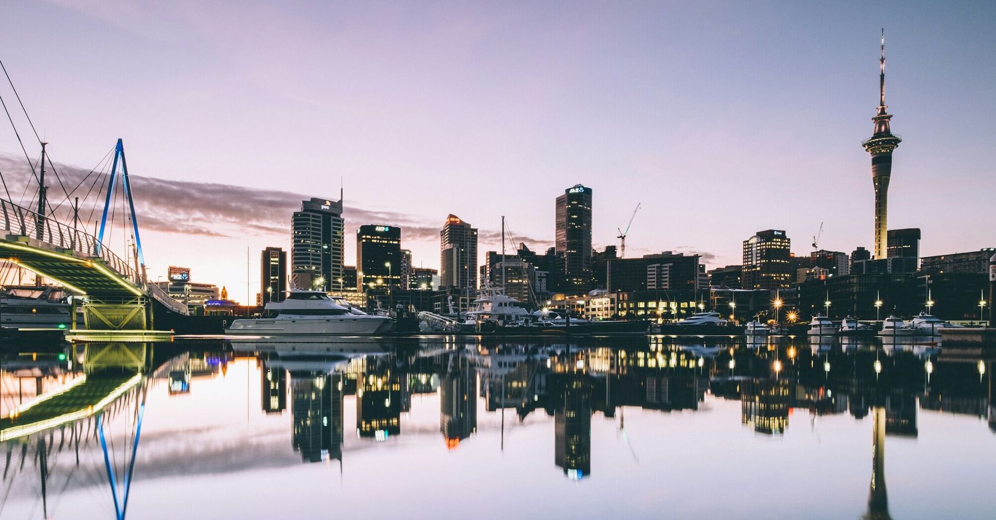 Auckland city skyline at dusk with reflections in the water