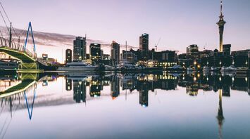 Auckland city skyline at dusk with reflections in the water