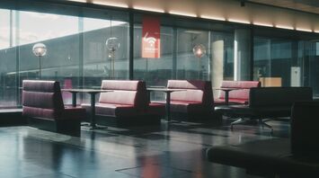 a waiting area with chairs and tables in front of large windows