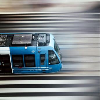 A blue train speeding along railway tracks in Sweden