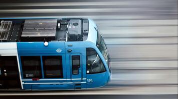 A blue train speeding along railway tracks in Sweden