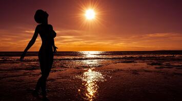 Nude person on the beach on the sunset