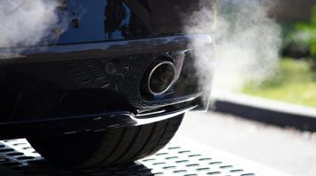 A car smoking from an exhaust pipe on the street on a sunny day
