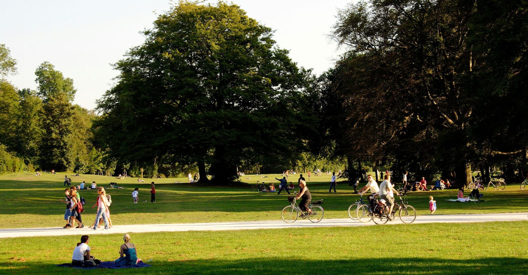 Many people enjoy the afternoon sun on the meadows of the English Garden