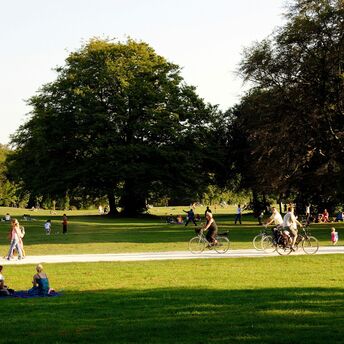 Many people enjoy the afternoon sun on the meadows of the English Garden