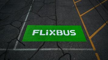 FlixBus logo painted on an asphalt bus parking spot