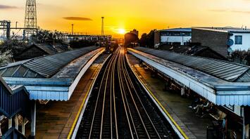 Sunset view of a railway station with empty platforms and tracks