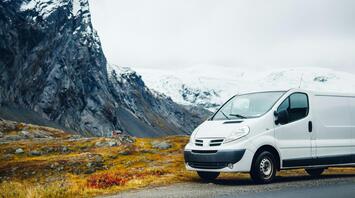 White minibus parked on a scenic mountain road