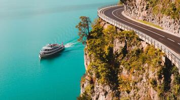 Picturesque landscape with a road, boat and mountains on the horizon