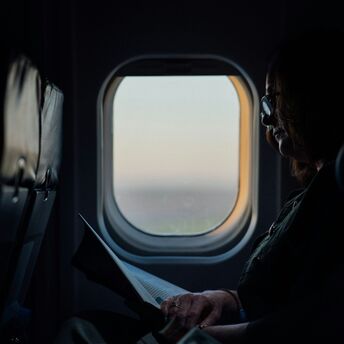 Passenger reading a book on an airplane