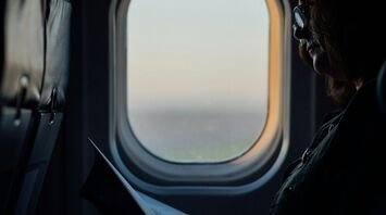 Passenger reading a book on an airplane