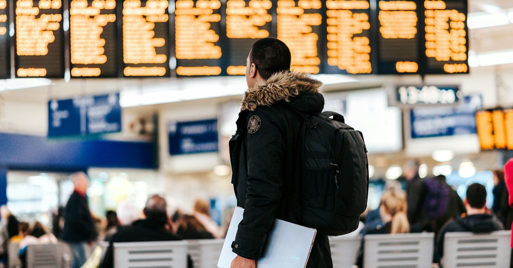 Traveler checking flight schedules at airport departure board