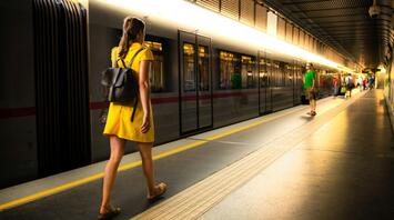 Woman in a yellow dress walking along a train platform