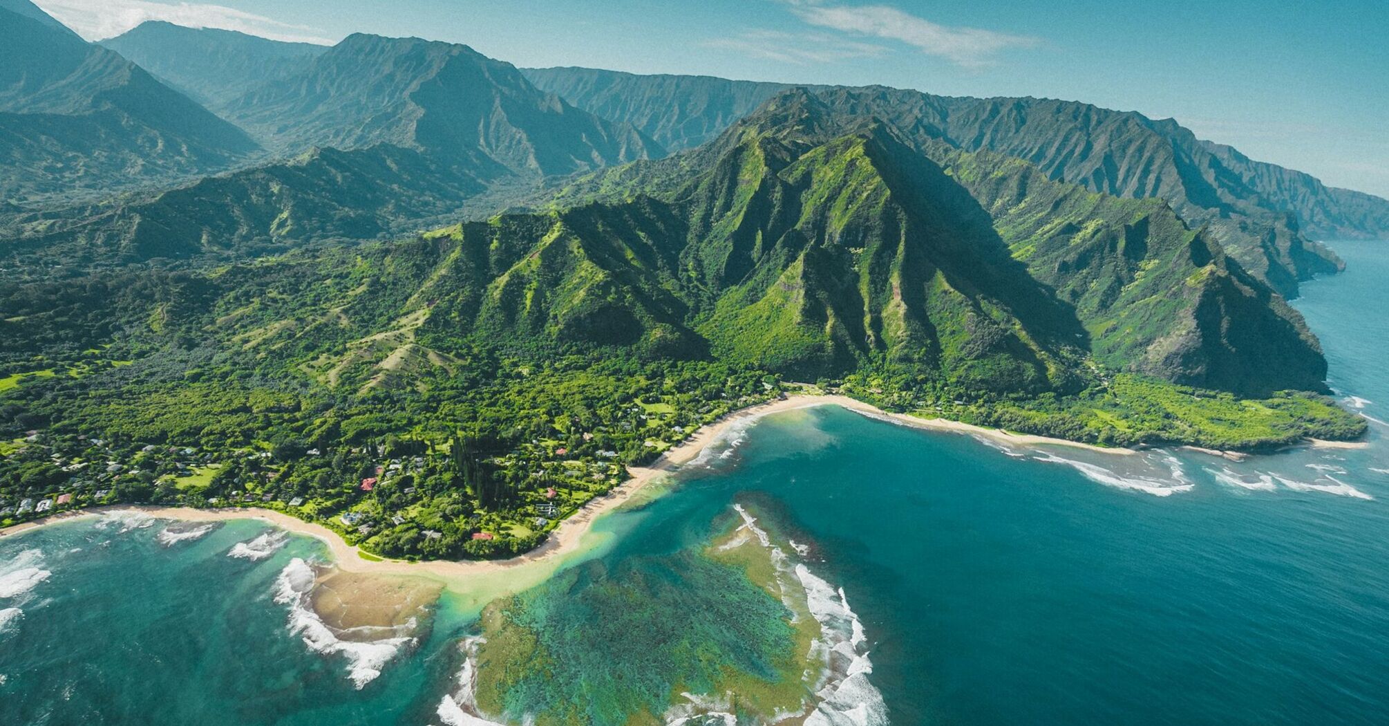 Aerial view of lush green mountains and coastline on Hawai'i Island