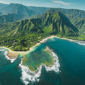 Aerial view of lush green mountains and coastline on Hawai'i Island
