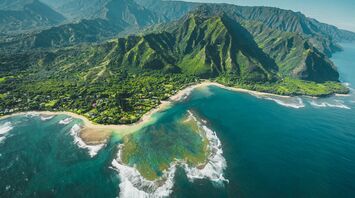 Aerial view of lush green mountains and coastline on Hawai'i Island