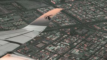 Aerial view from a Qatar Airways plane over a cityscape