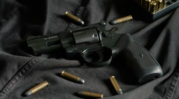 Revolver with bullets on black fabric