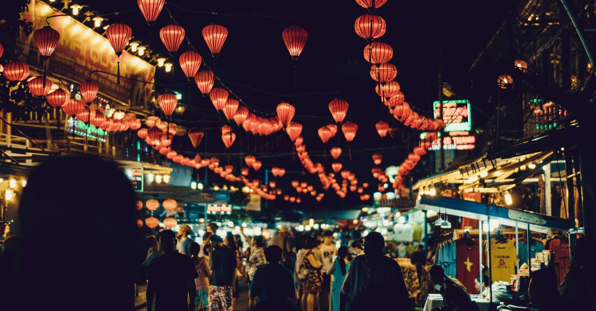 Busy Vietnamese night market adorned with red lanterns