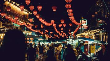 Busy Vietnamese night market adorned with red lanterns