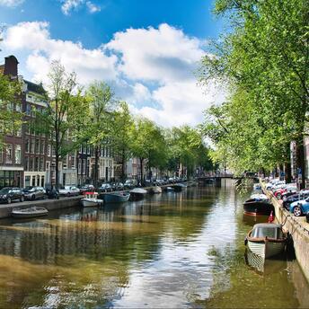 A peaceful day on one of Amsterdam's picturesque canals, where historic buildings are reflected in the water