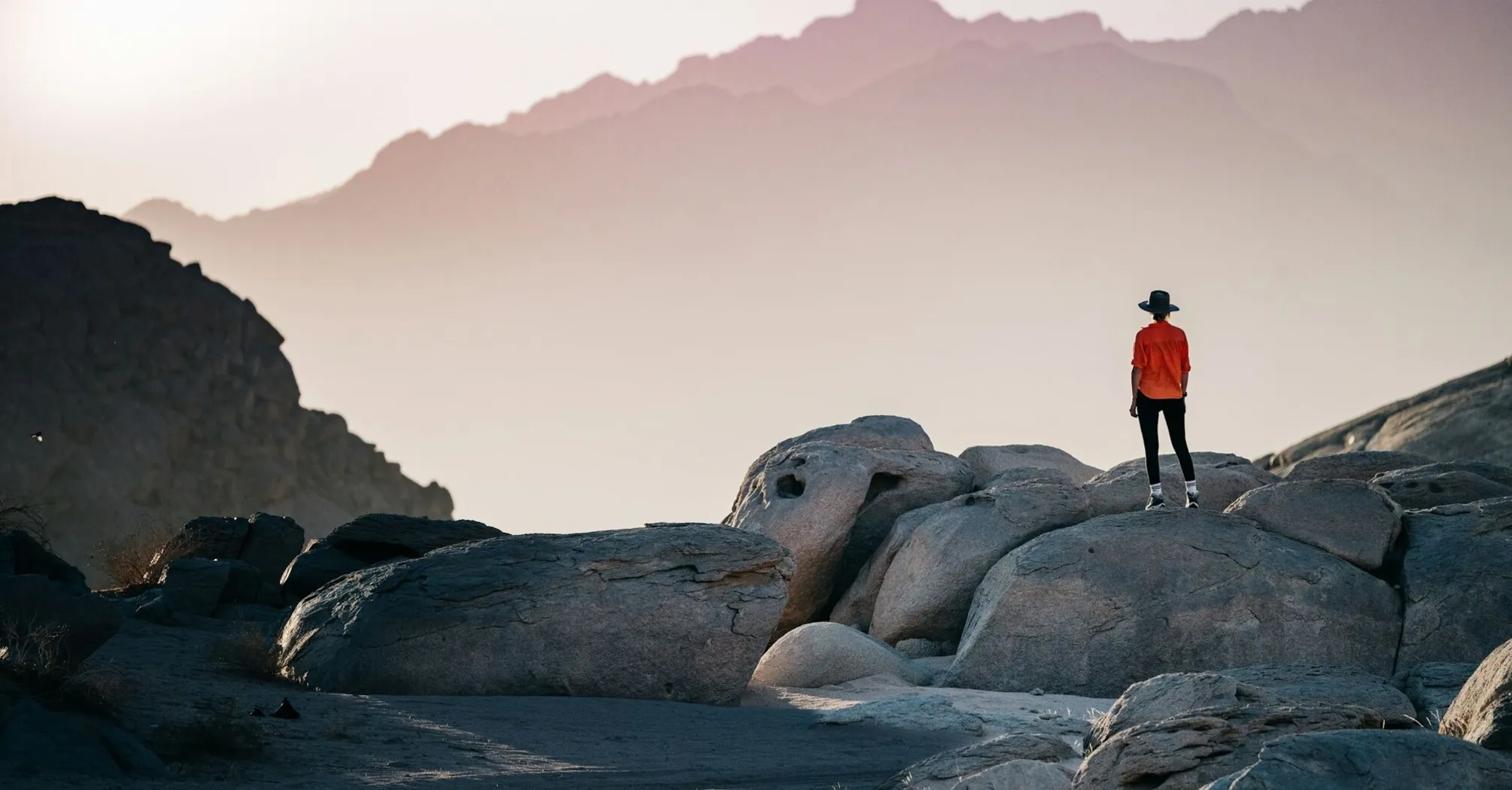 Traveler exploring rocky terrain at sunset