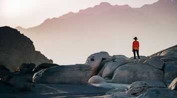 Traveler exploring rocky terrain at sunset