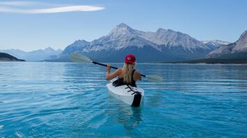 A tourist enjoys kayaking on the clear waters of a European lake