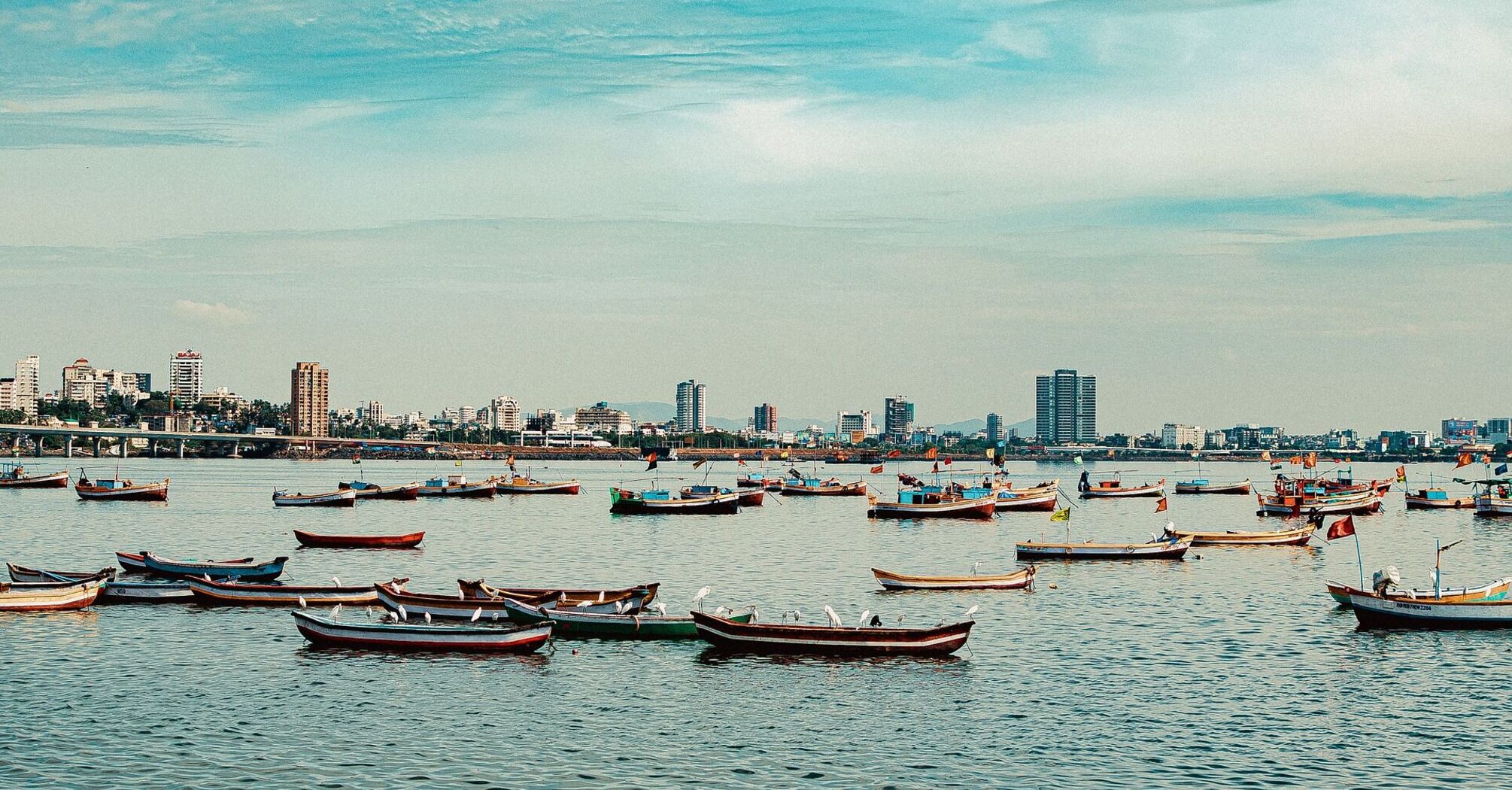 Boats in Mumbai with city skyline in the background